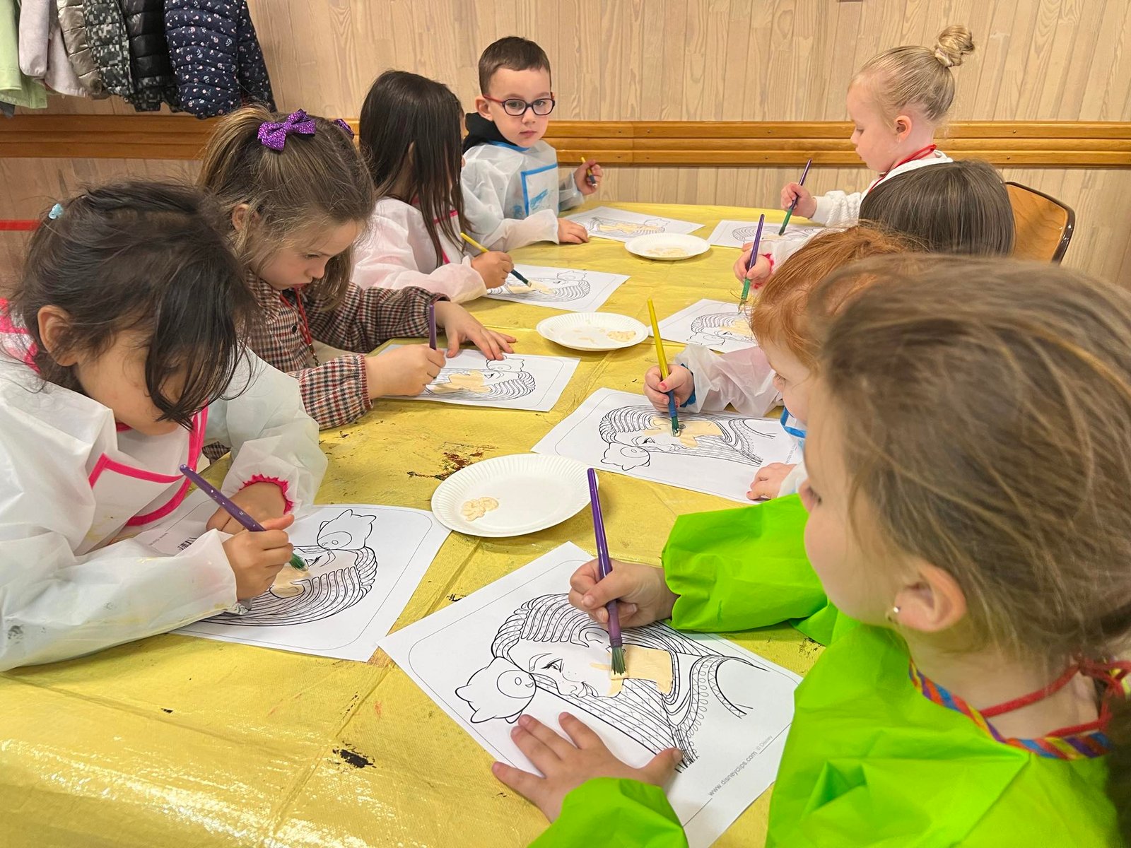 Enfants concentr&eacute;s sur du coloriage autour d'une table